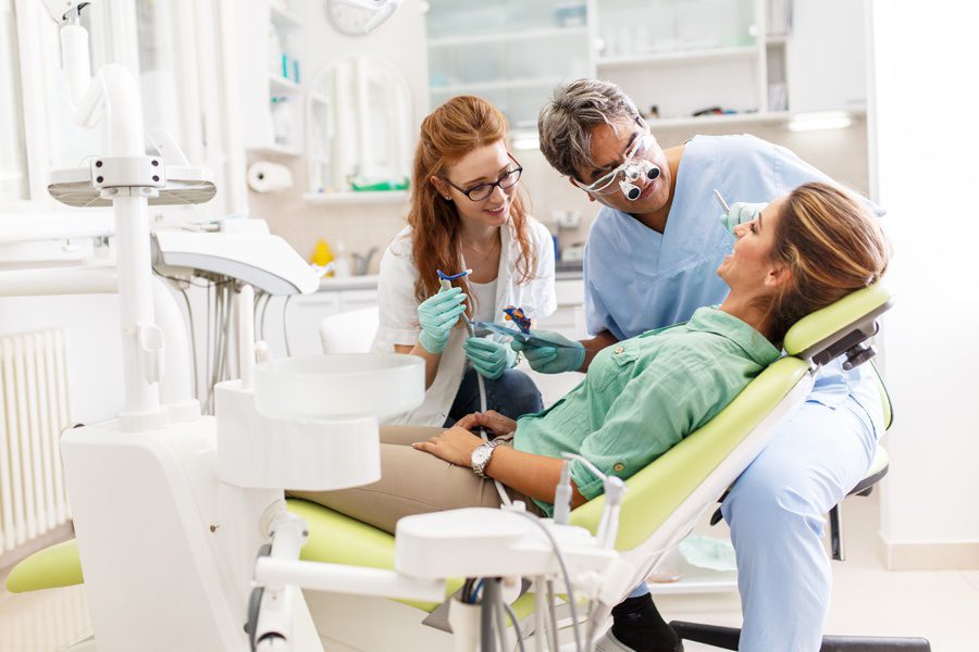 团体牙科保险-牙医和牙医助理进行清洁